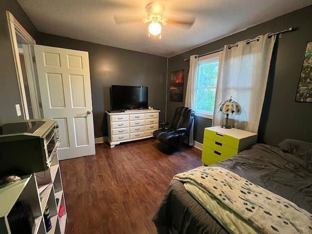 bedroom with baseboards, ceiling fan, and wood finished floors