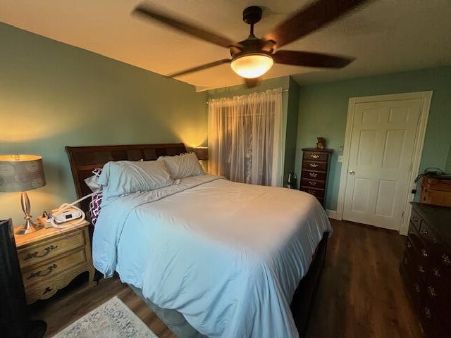 bedroom featuring a ceiling fan and dark wood-style floors