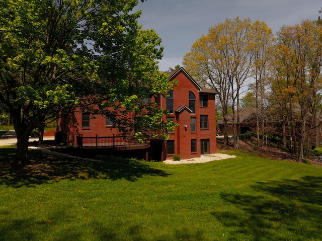 back of property featuring a lawn and brick siding