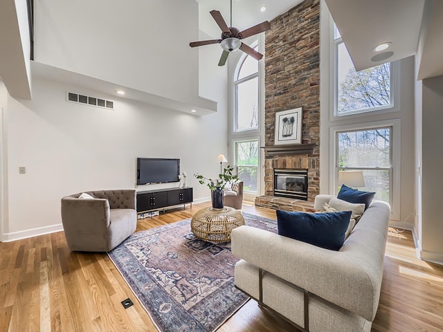 living area with a towering ceiling, baseboards, and visible vents