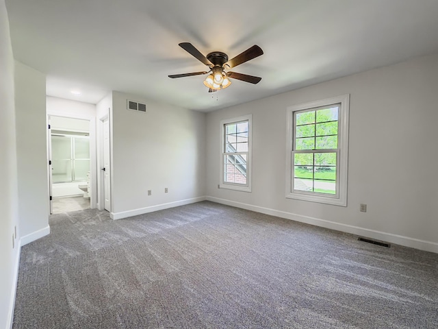 spare room with visible vents, a ceiling fan, baseboards, and carpet flooring