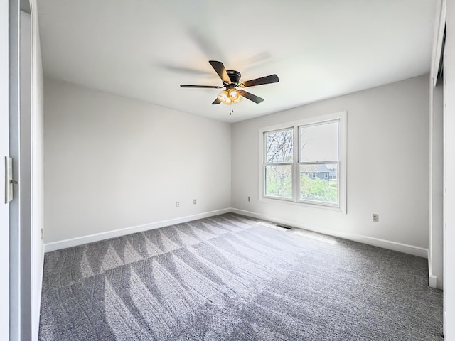 carpeted spare room featuring a ceiling fan, baseboards, and visible vents
