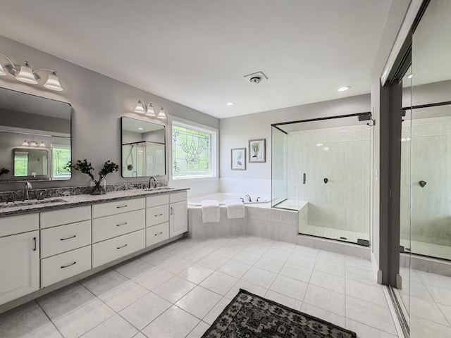 bathroom with double vanity, a sink, a garden tub, and a stall shower