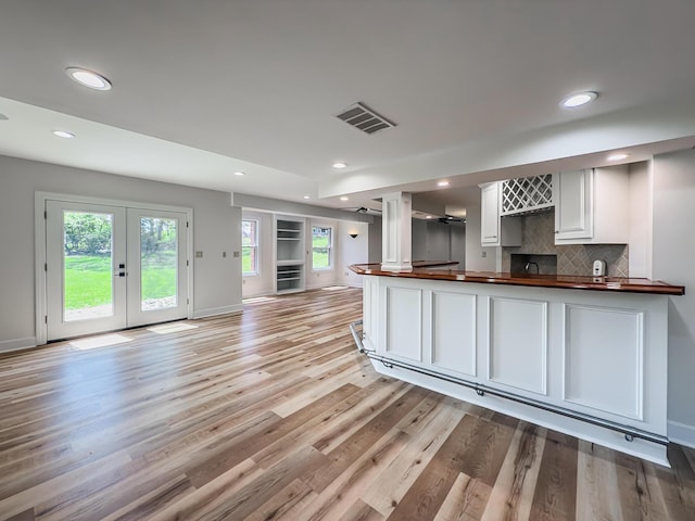 kitchen with butcher block countertops, recessed lighting, white cabinets, french doors, and light wood-style flooring