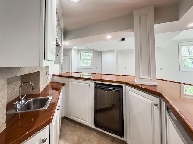 kitchen with white cabinets, a sink, tasteful backsplash, wine cooler, and visible vents