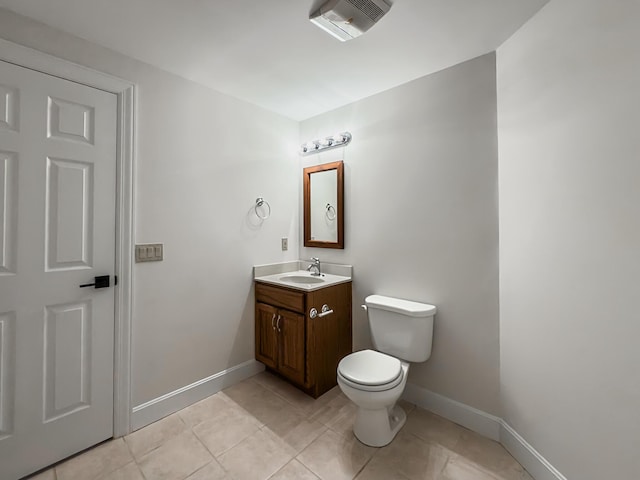 bathroom with visible vents, vanity, toilet, baseboards, and tile patterned floors