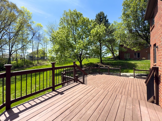 wooden deck featuring a lawn