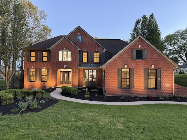 view of front facade with brick siding and a front yard