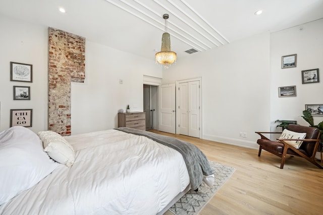 bedroom with light wood-style floors, baseboards, recessed lighting, and a towering ceiling
