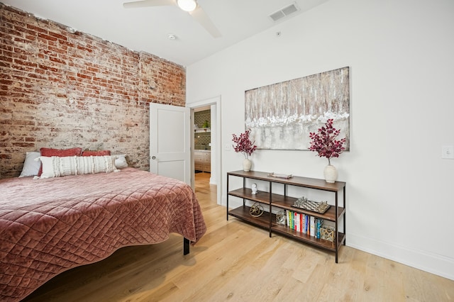 bedroom with brick wall, wood finished floors, baseboards, and ceiling fan