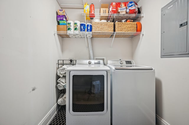laundry room with electric panel, washer and dryer, and baseboards