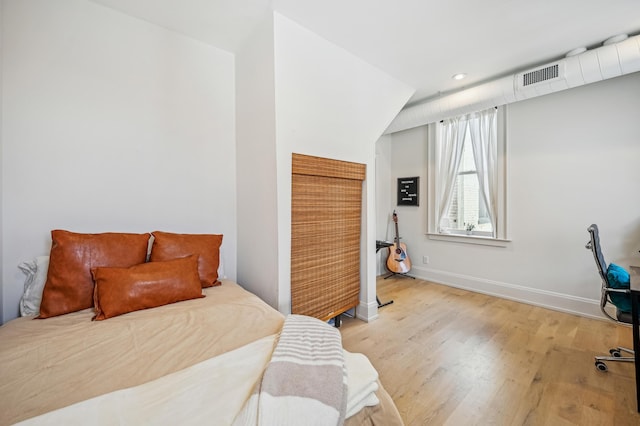 bedroom with light wood-type flooring, baseboards, and recessed lighting