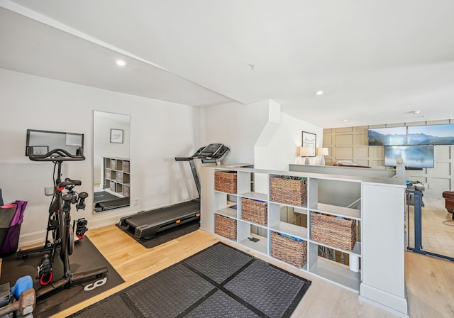 exercise room with wood finished floors and recessed lighting