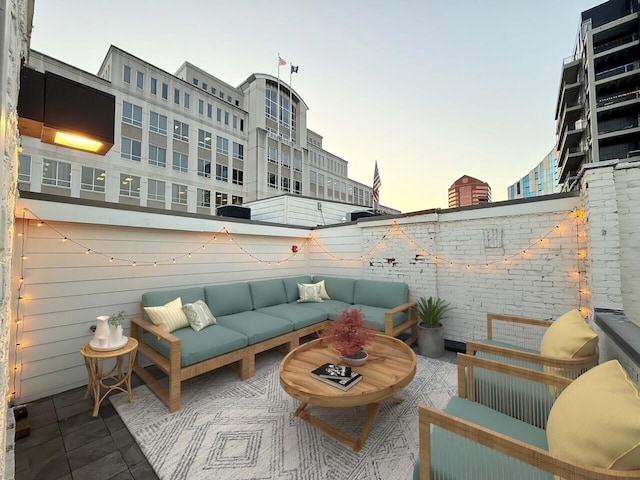 patio terrace at dusk with an outdoor hangout area and a fenced backyard