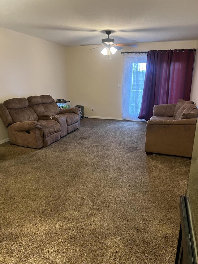 carpeted living area featuring baseboards and a ceiling fan