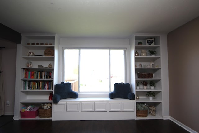 living area with baseboards and wood finished floors