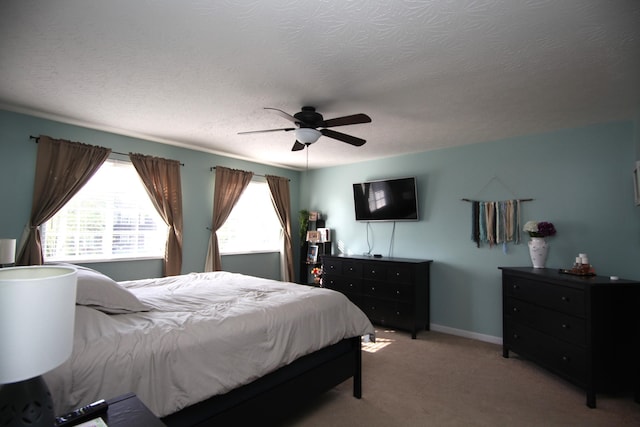 bedroom featuring baseboards, a ceiling fan, a textured ceiling, and light colored carpet
