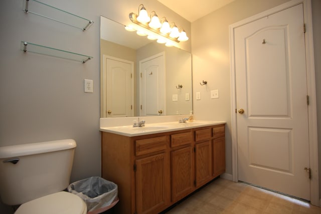 full bath featuring a sink, toilet, and double vanity