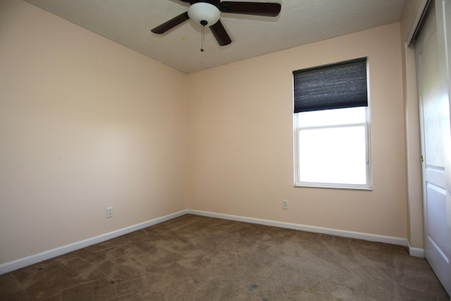 empty room with baseboards, a ceiling fan, and carpet