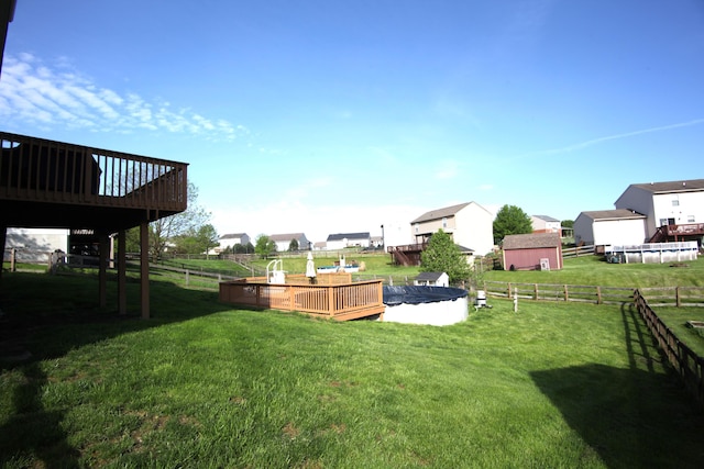 view of yard with a fenced backyard, a wooden deck, and a residential view