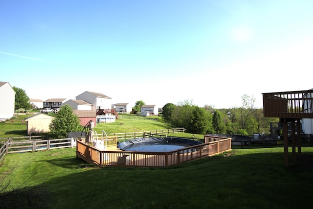 view of swimming pool featuring a yard, fence, and a fenced in pool