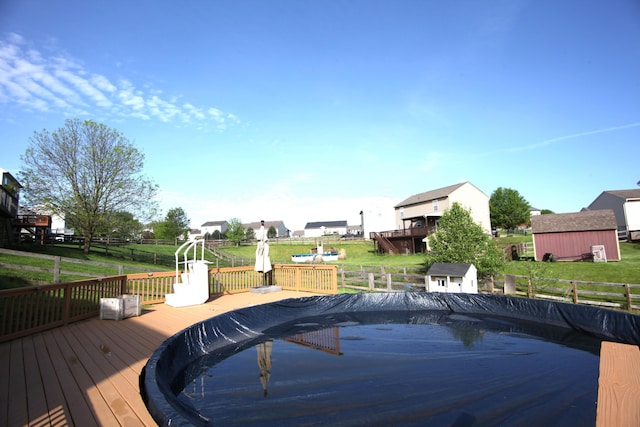 view of pool featuring a lawn, fence, a fenced in pool, and a wooden deck