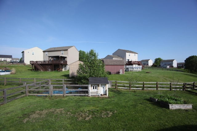 view of yard with a storage shed, an outbuilding, a fenced backyard, and a vegetable garden