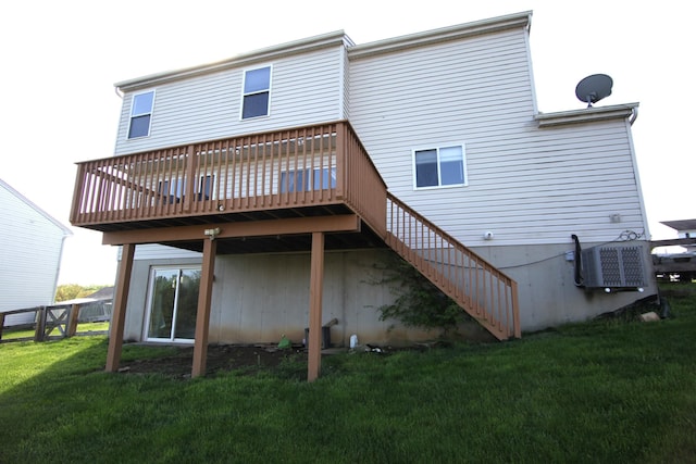 rear view of house with a lawn, stairway, and a wooden deck