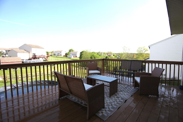 wooden terrace with an outdoor living space, a yard, and a residential view