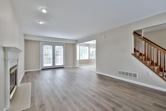 1609 Woodfield Ct, Hebron, KY 41048 - unfurnished living room with wood finished floors, a tiled fireplace, and stairs