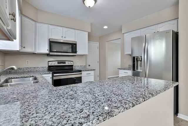 1609 Woodfield Ct, Hebron, KY 41048 - kitchen featuring appliances with stainless steel finishes, light stone countertops, white cabinetry, a peninsula, and recessed lighting