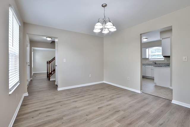 1609 Woodfield Ct, Hebron, KY 41048 - spare room with a chandelier, light wood-style floors, and stairs