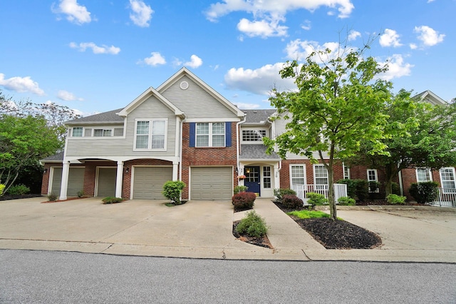 multi unit property featuring driveway, brick siding, and an attached garage