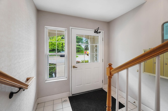 doorway to outside featuring plenty of natural light, baseboards, light tile patterned floors, and stairs