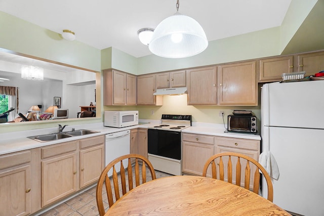 kitchen featuring white appliances, a sink, light brown cabinetry, and under cabinet range hood