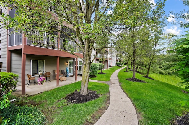view of green lawn featuring a patio