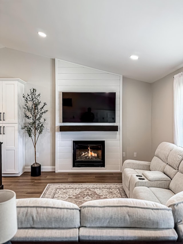 living area featuring a fireplace, wood finished floors, baseboards, lofted ceiling, and recessed lighting