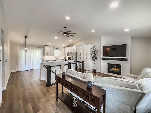 living room featuring vaulted ceiling, a ceiling fan, recessed lighting, and dark wood-type flooring
