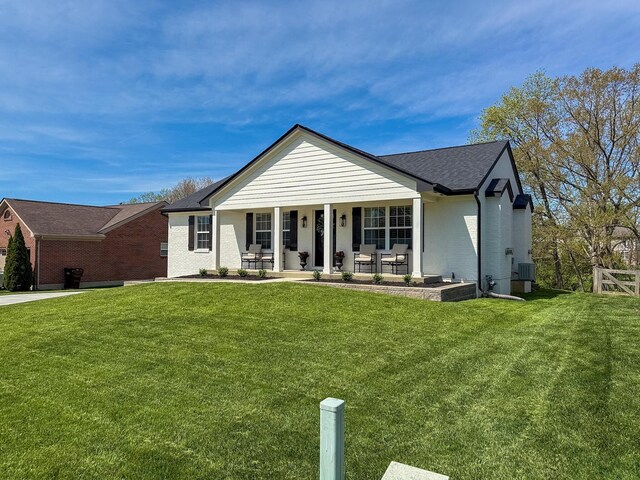 view of front of home featuring a front yard, roof with shingles, brick siding, central AC unit, and a porch
