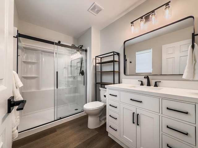 bathroom with visible vents, a stall shower, wood finished floors, and toilet