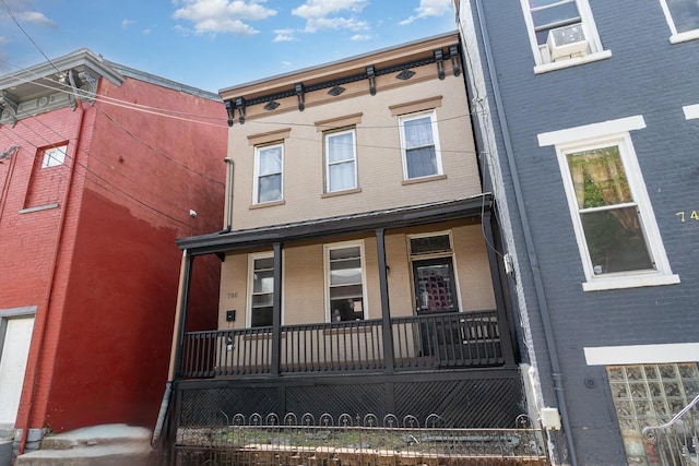 multi unit property featuring a porch and brick siding
