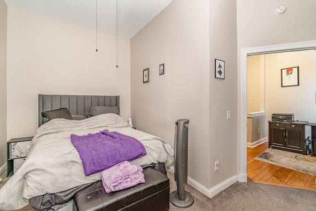 bedroom featuring baseboards, lofted ceiling, and carpet