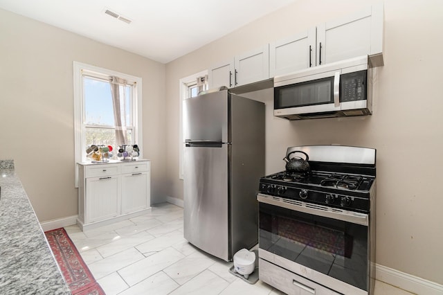 kitchen with visible vents, marble finish floor, baseboards, white cabinets, and appliances with stainless steel finishes