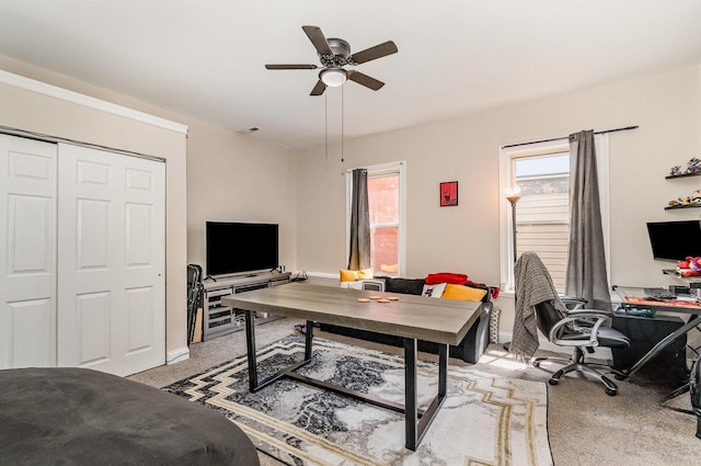 office with baseboards, visible vents, a ceiling fan, and light colored carpet