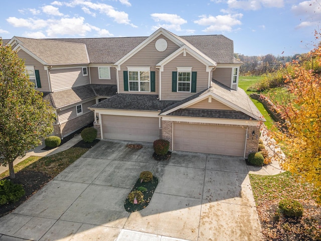 view of front of property featuring brick siding, an attached garage, driveway, and a shingled roof