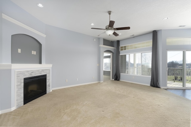 unfurnished living room featuring carpet flooring, ceiling fan, a tiled fireplace, recessed lighting, and baseboards