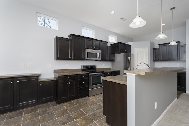 kitchen featuring visible vents, a kitchen island with sink, recessed lighting, hanging light fixtures, and stainless steel appliances