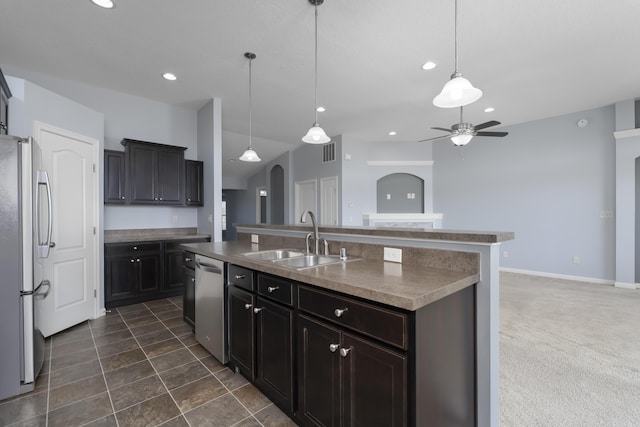 kitchen with recessed lighting, a sink, appliances with stainless steel finishes, and a center island with sink