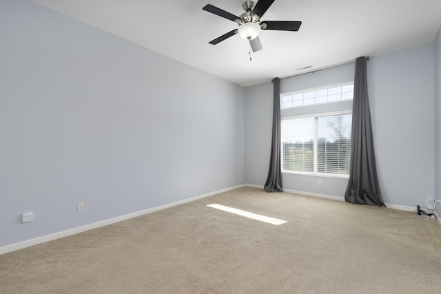 unfurnished room featuring light colored carpet, a ceiling fan, baseboards, and visible vents
