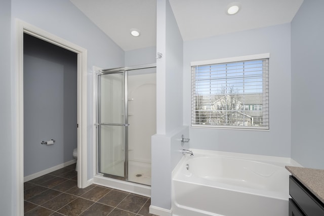 bathroom featuring tile patterned flooring, vanity, toilet, a bath, and a stall shower